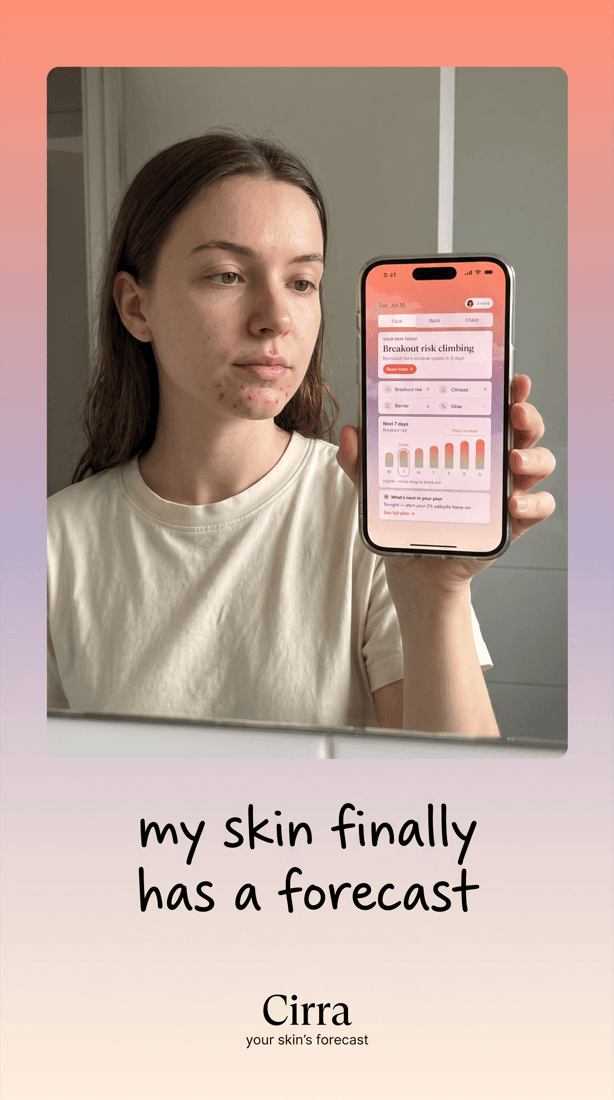 A woman holding her phone in front of a mirror showing the Cirra home screen.